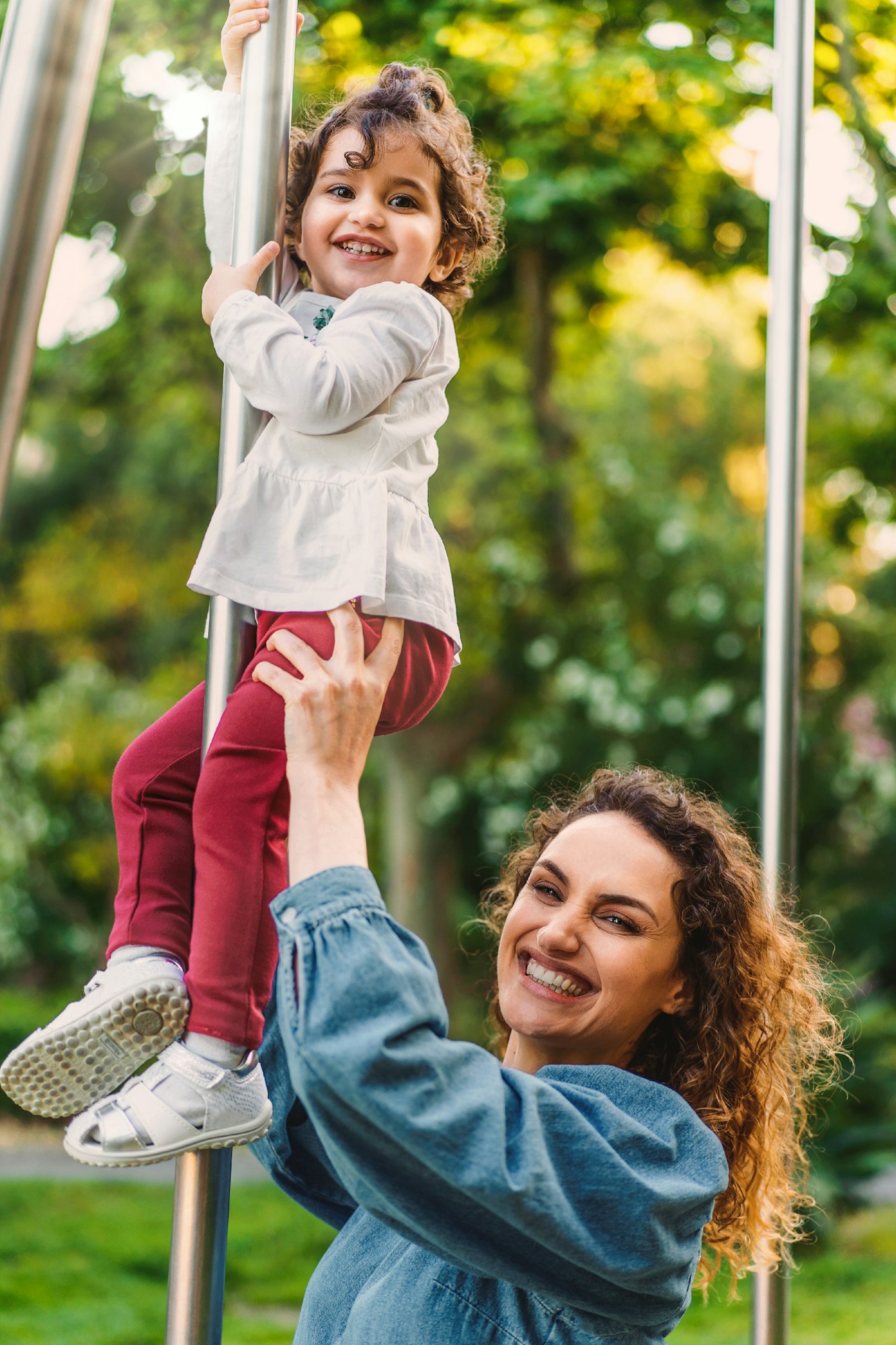 Joyful single mother and daughter smiling and playing together